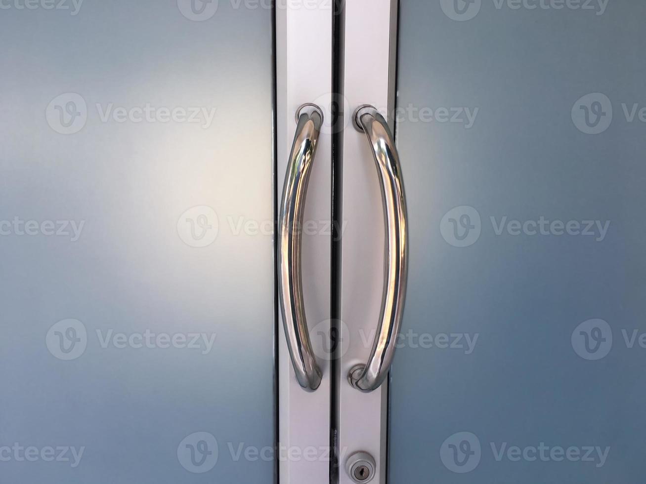 Glassdoors or front doors of the office which has stainless handlebars on their frame, soft and selective focus. photo