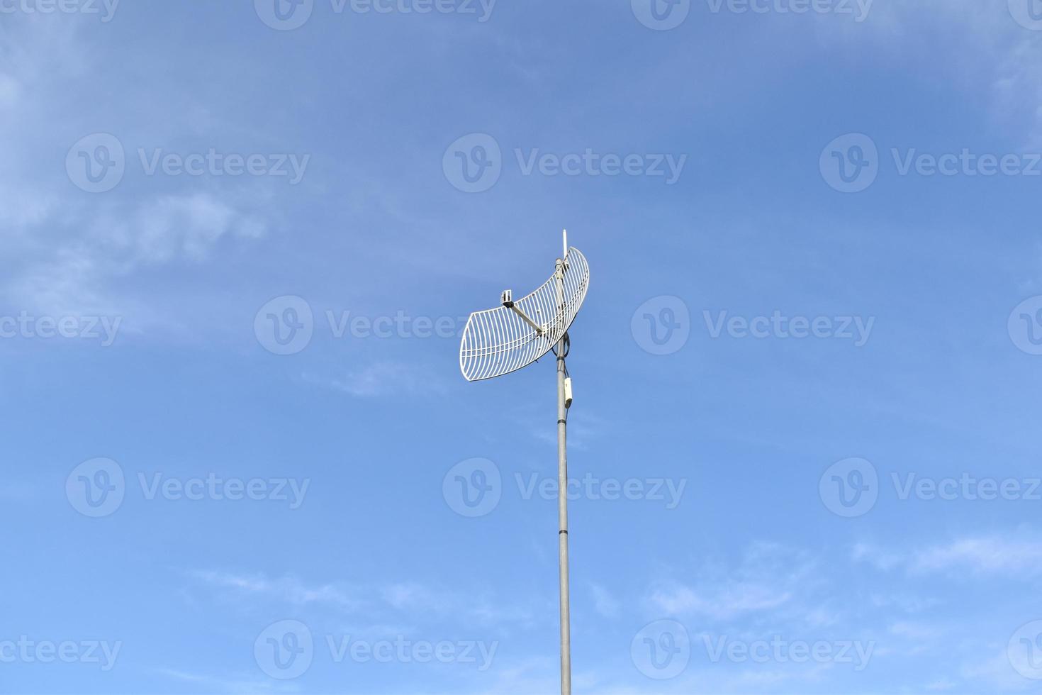 Outdoor internet wifi receiver and repeater antenna on the roof of the building with clear bluesky background. photo