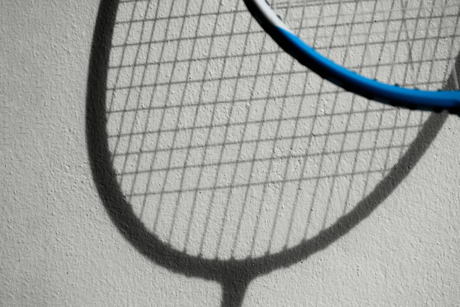 The shadow of badminton rackets on white wall, soft and selective focus, concept for badminton sport lover around the world. photo