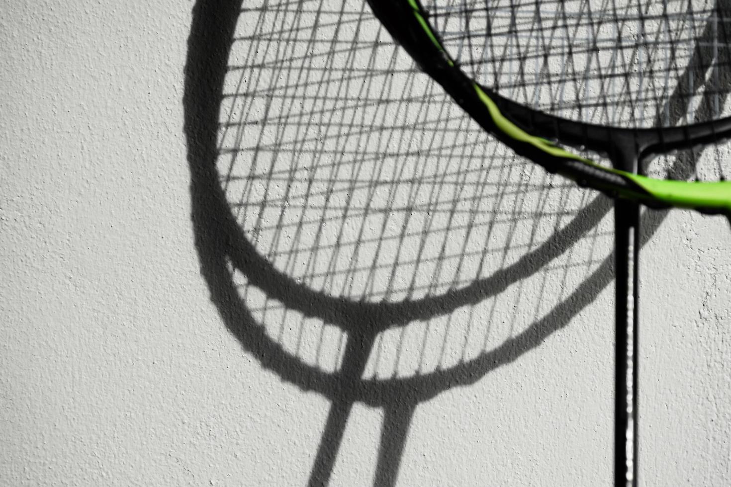 la sombra de las raquetas de bádminton en la pared blanca, enfoque suave y selectivo, concepto para los amantes del deporte de bádminton en todo el mundo. foto