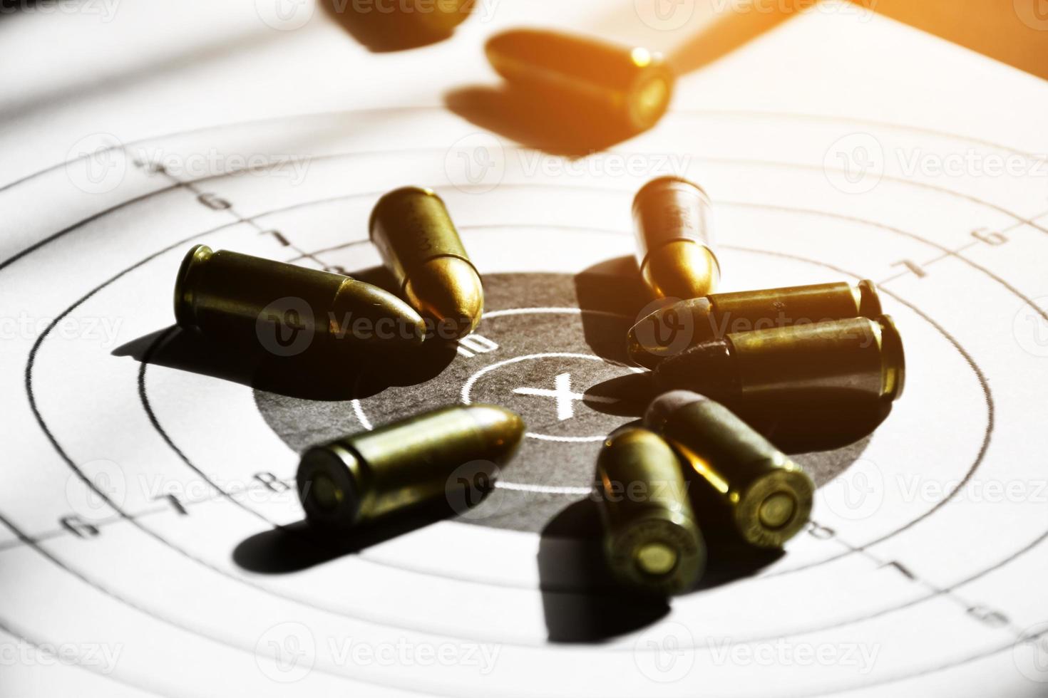 9mm bullets and 9mm bullet case on shooting target paper, soft and selective focus photo