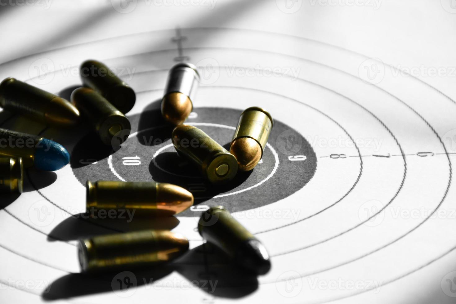 9mm bullets and 9mm bullet case on shooting target paper, soft and selective focus photo