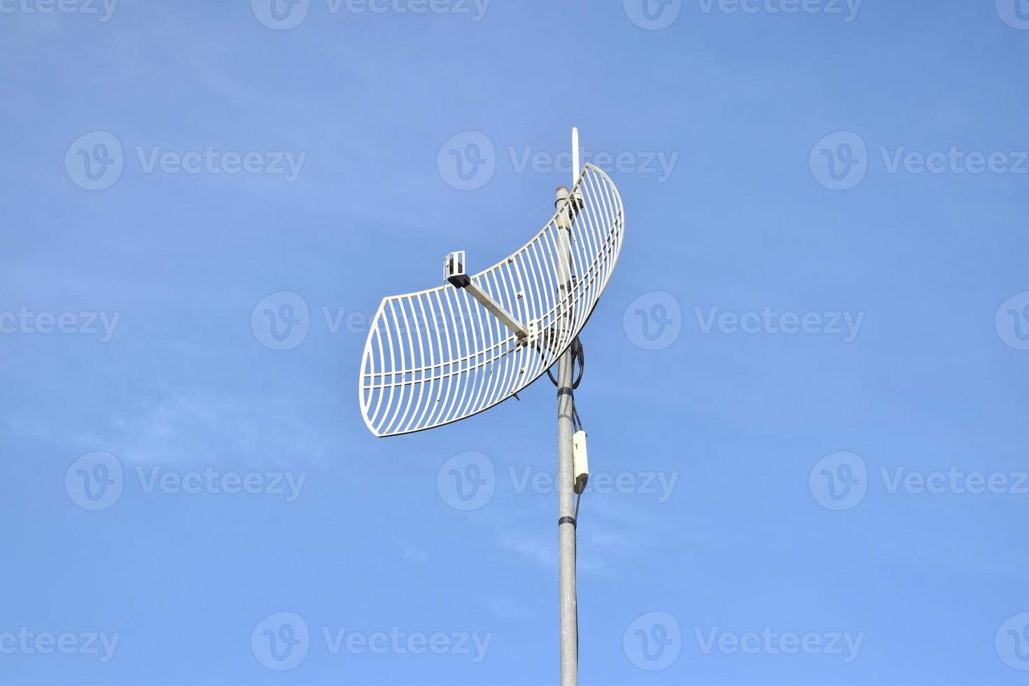 Outdoor internet wifi receiver and repeater antenna on the roof of the building with clear bluesky background. photo