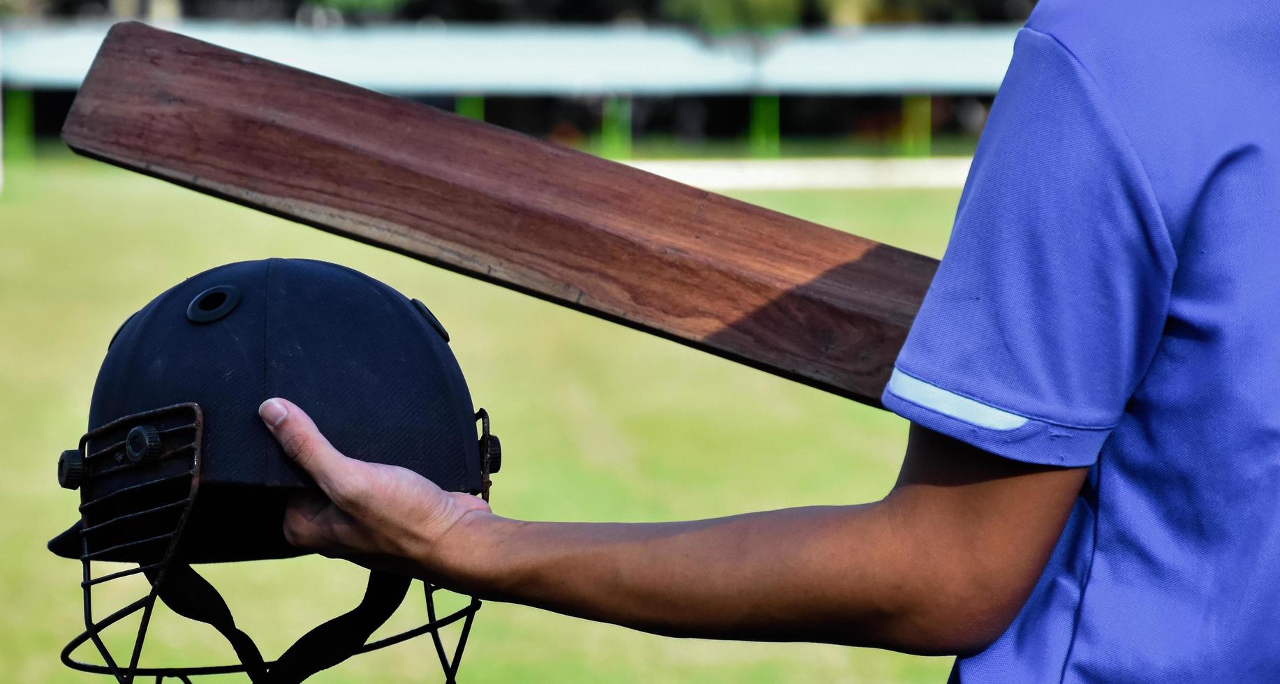 casco antiguo del deporte de cricket en la mano, concepto para los amantes del cricket de todo el mundo. foto