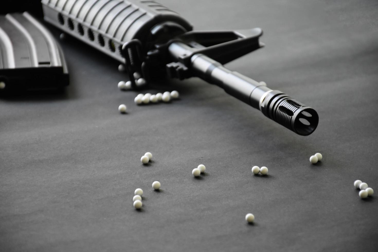 Closeup of white plastic bullets of airsoft gun or bb gun on wooden floor, soft and selective focus on white bullets. photo