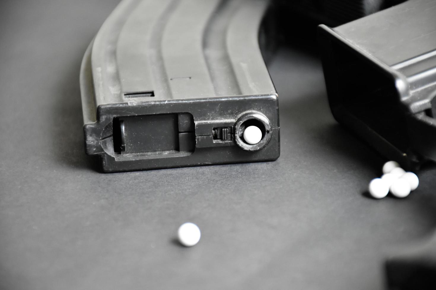 Closeup of white plastic bullets of airsoft gun or bb gun on wooden floor, soft and selective focus on white bullets. photo