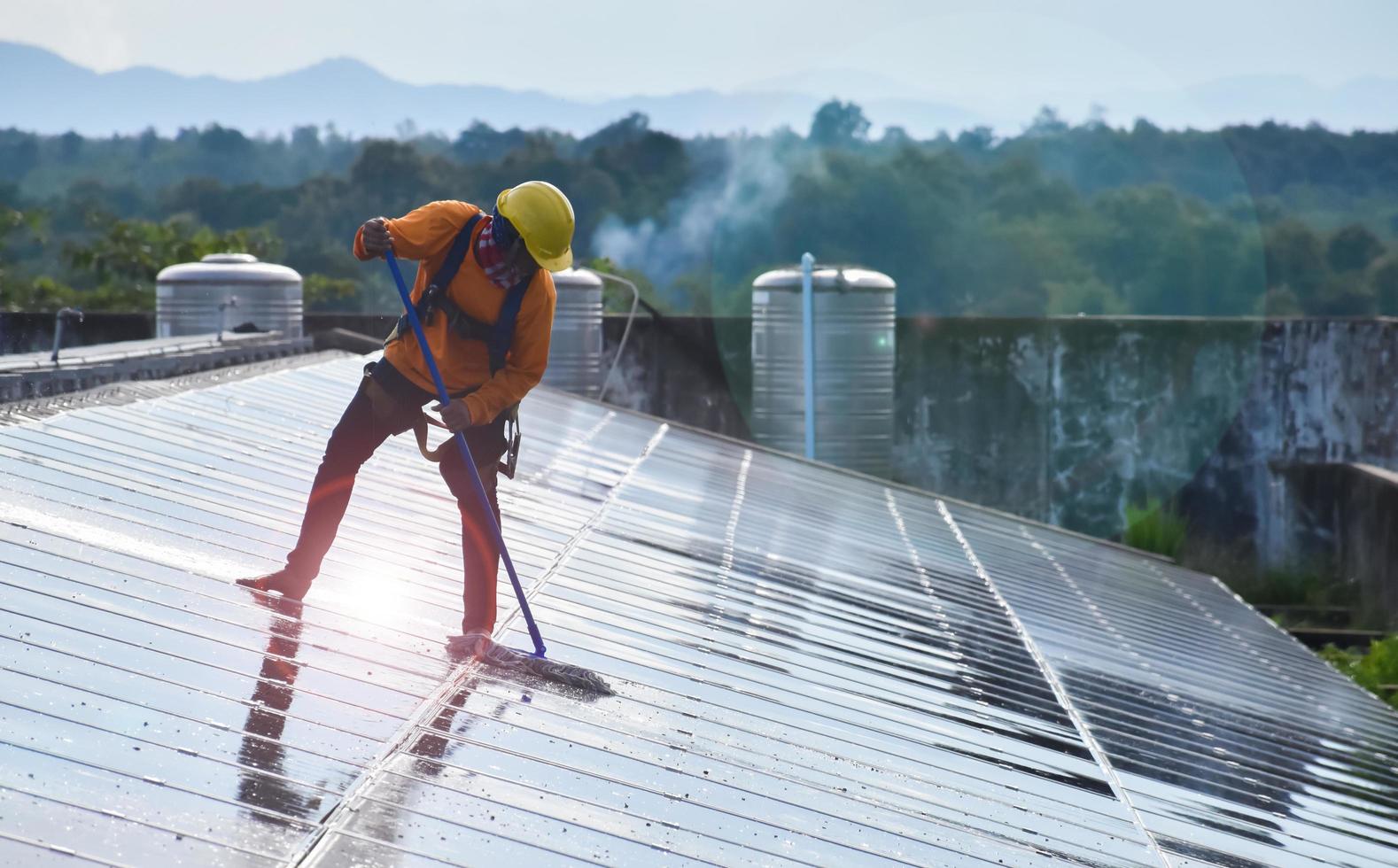 Los técnicos fotovoltaicos estaban limpiando y lavando la superficie de los paneles solares que tenían polvo y caca de pájaros. foto