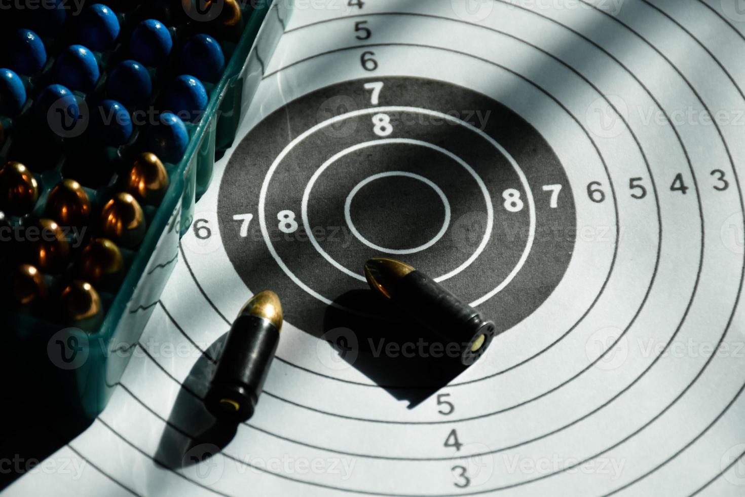 9mm bullets and 9mm bullet case on shooting target paper, soft and selective focus photo