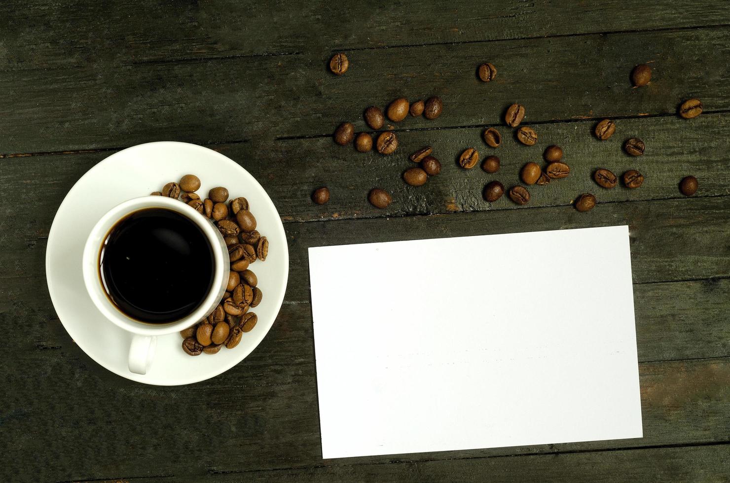a cup of coffee with coffee beans on wooden table.Flatlay, mock up. photo