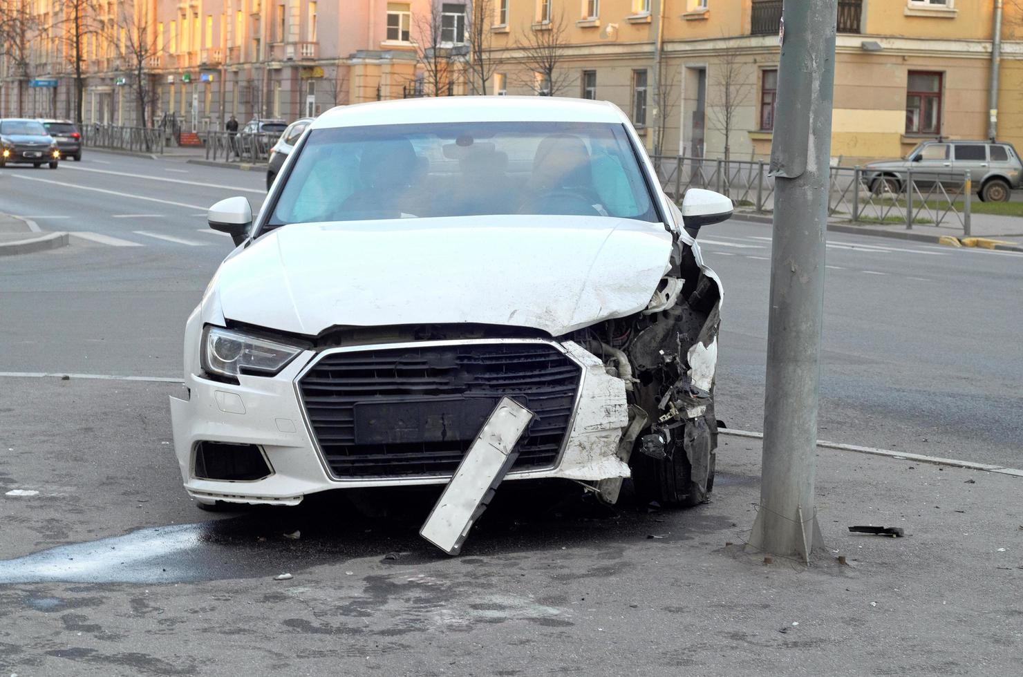 la parte delantera del coche averiado como consecuencia del accidente en el poste. seguro de accidentes de coche foto