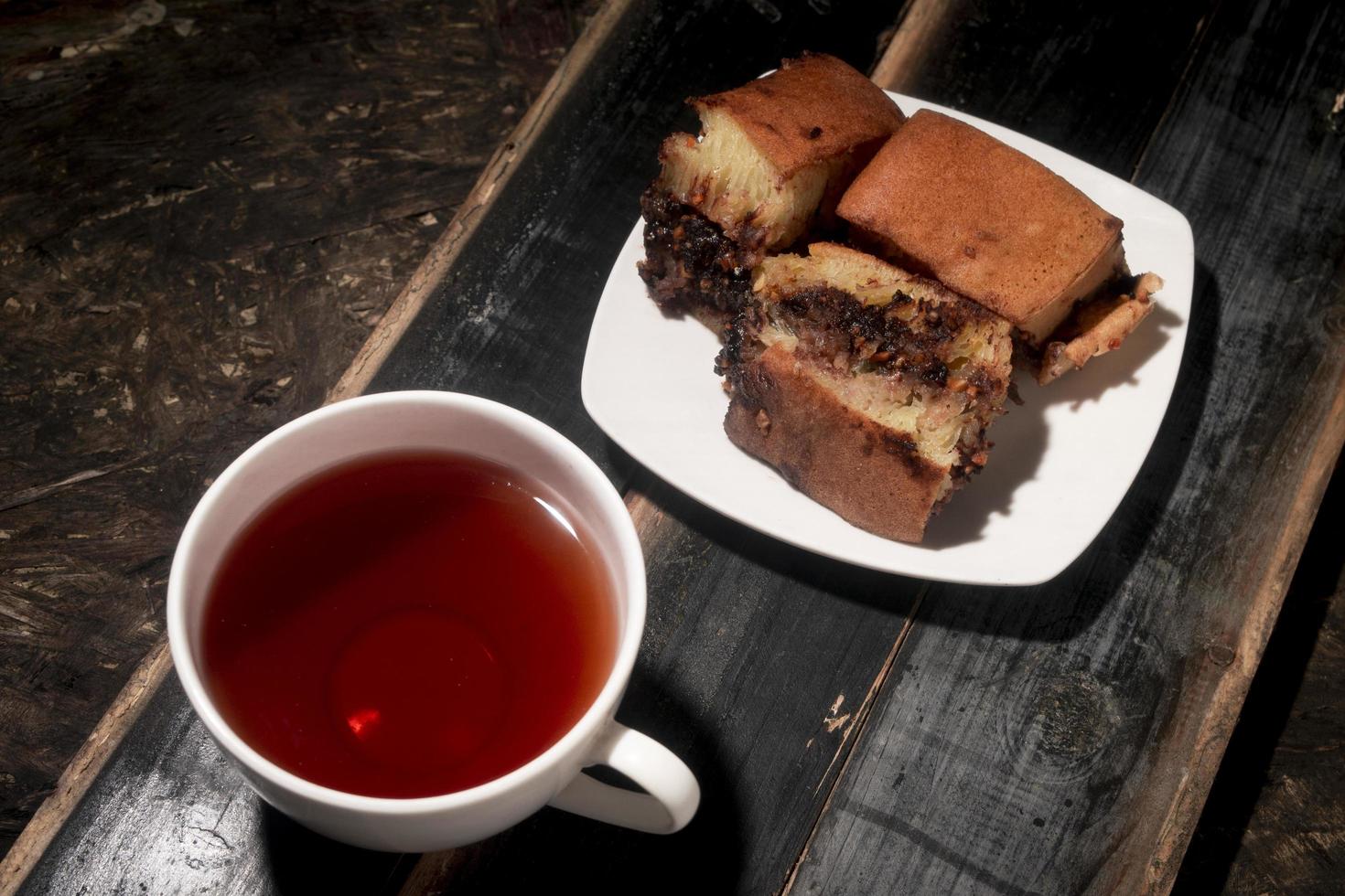 sweet cake and tea on wooden table photo