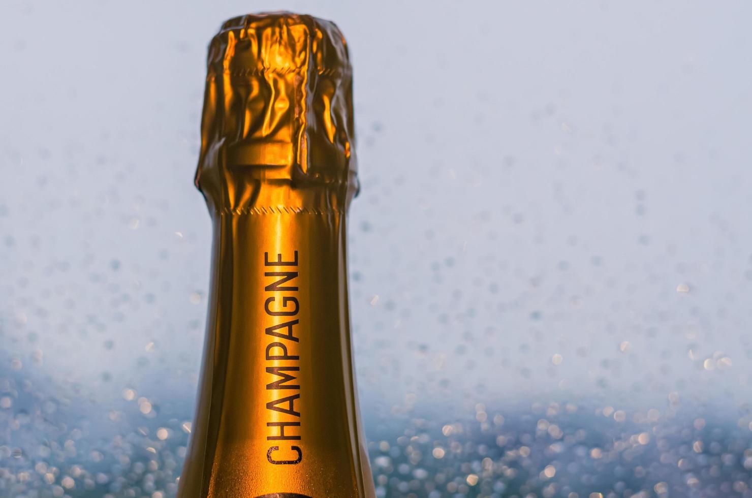 Top of shining Champagne bottle with rain drop on window background. photo