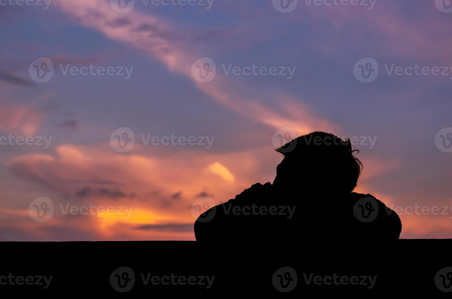 Silhouette of asian man stay alone with dusk sky background. Depression and mental health concept. photo
