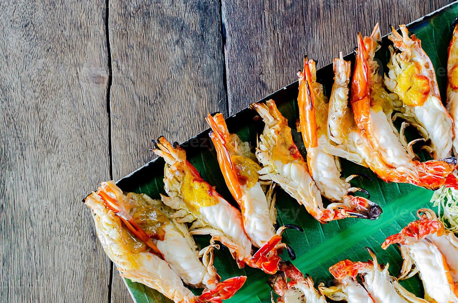 Charcoal grilled river prawns on wooden table. Thailand famous dish. photo