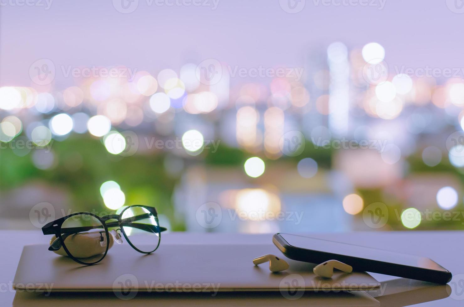 Laptop, smartphone and earphone are turning off put on table photo