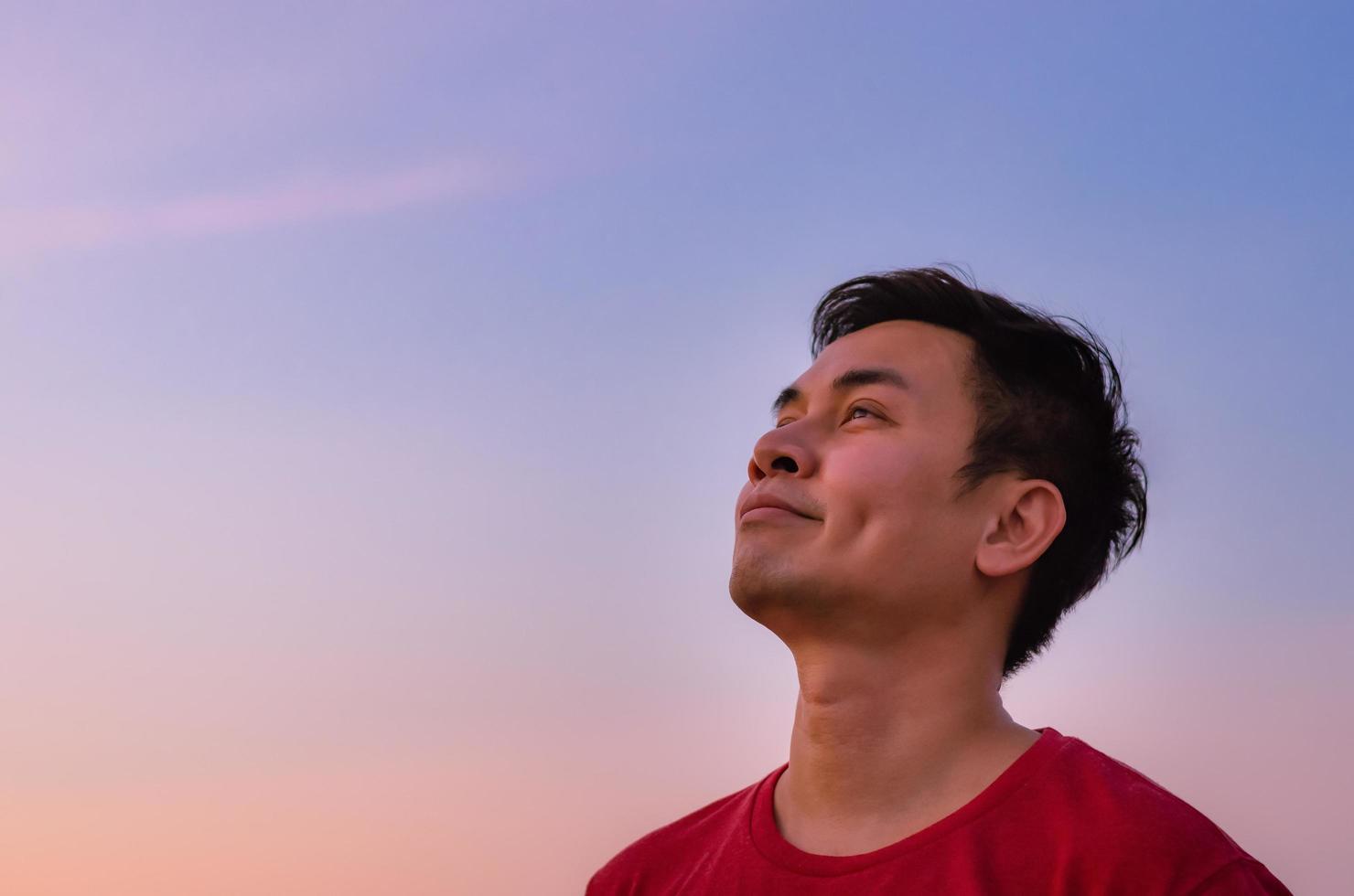 Asian man looking up to sky. Positive mental health and emotion face expression. photo