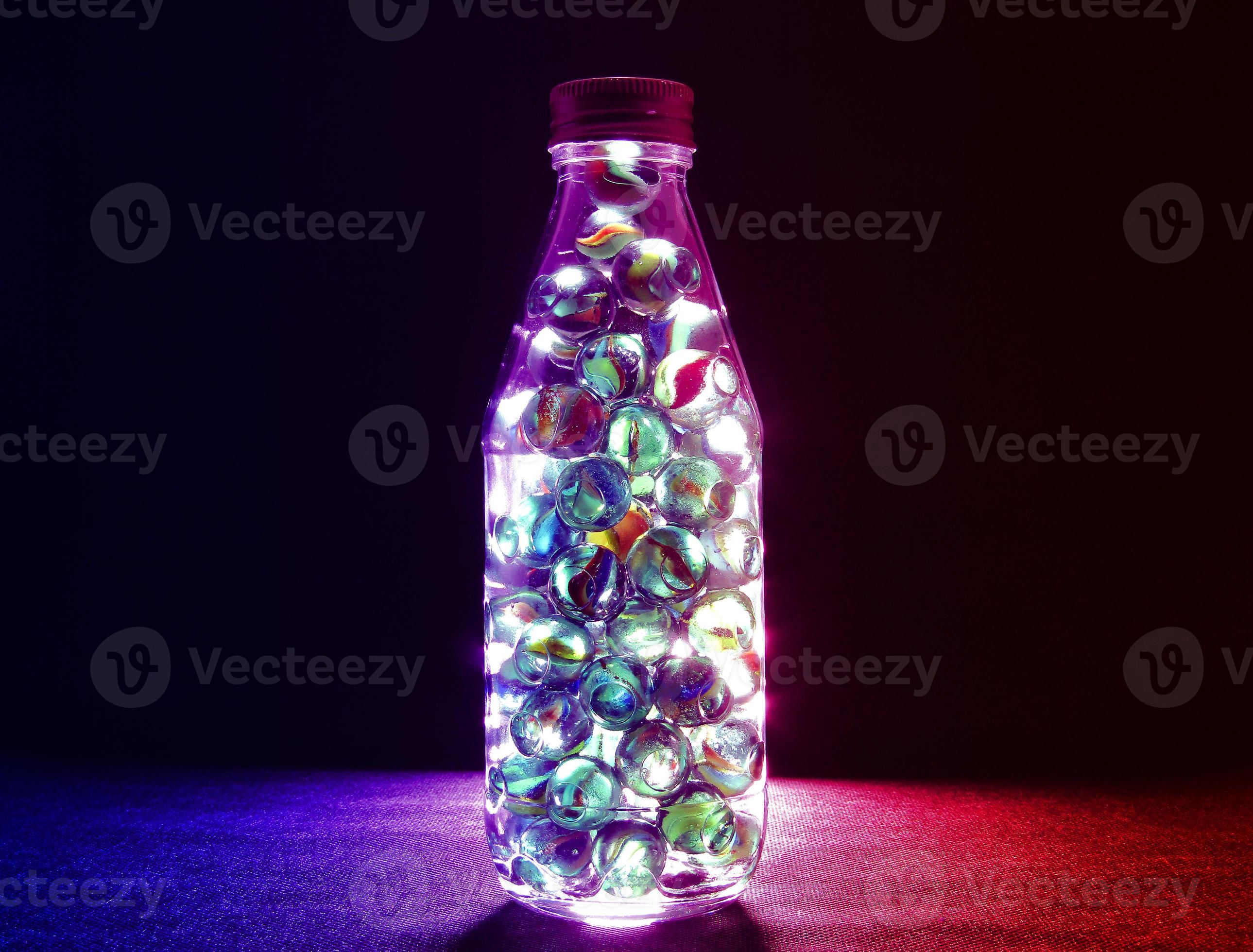 Closeup shot of various colored glass marbles inside a bottle with