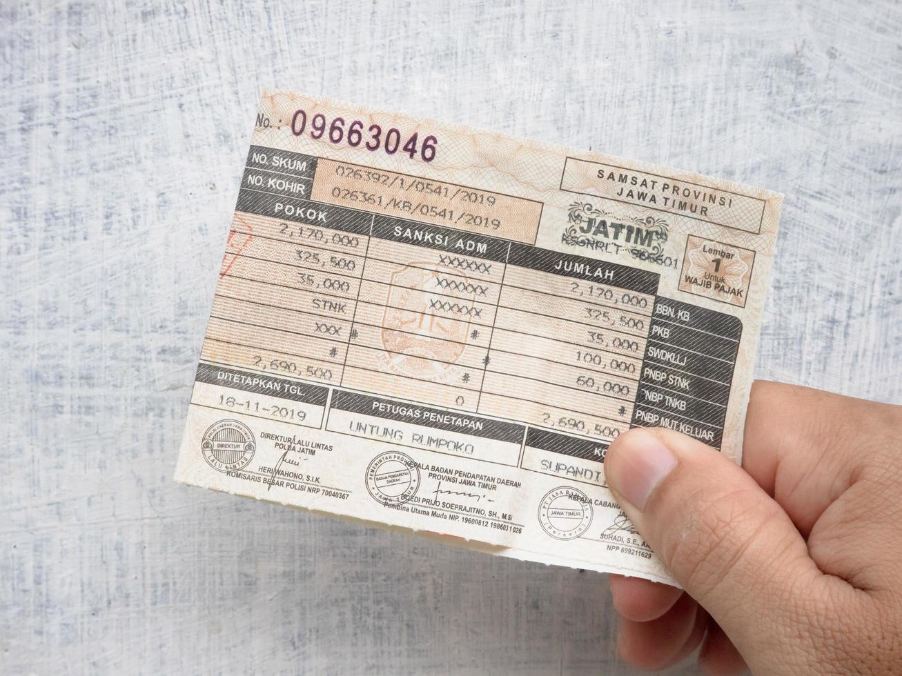 Sidoarjo, Jawa timur, Indonesia, 2022 - male hand-held motorcycle vehicle annual tax letter photo