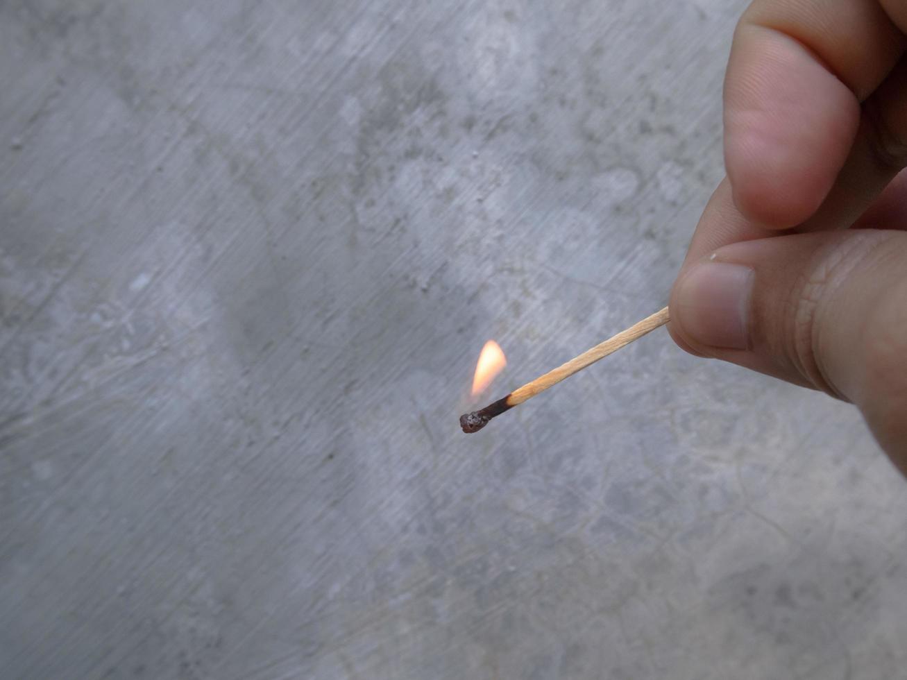 un fósforo de madera en llamas en la mano de un hombre foto