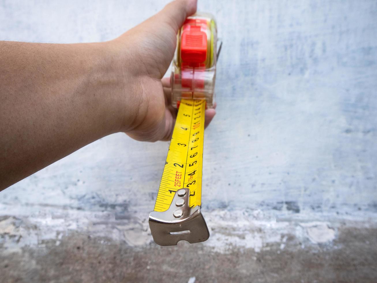 a man holding a measuring tape measure photo