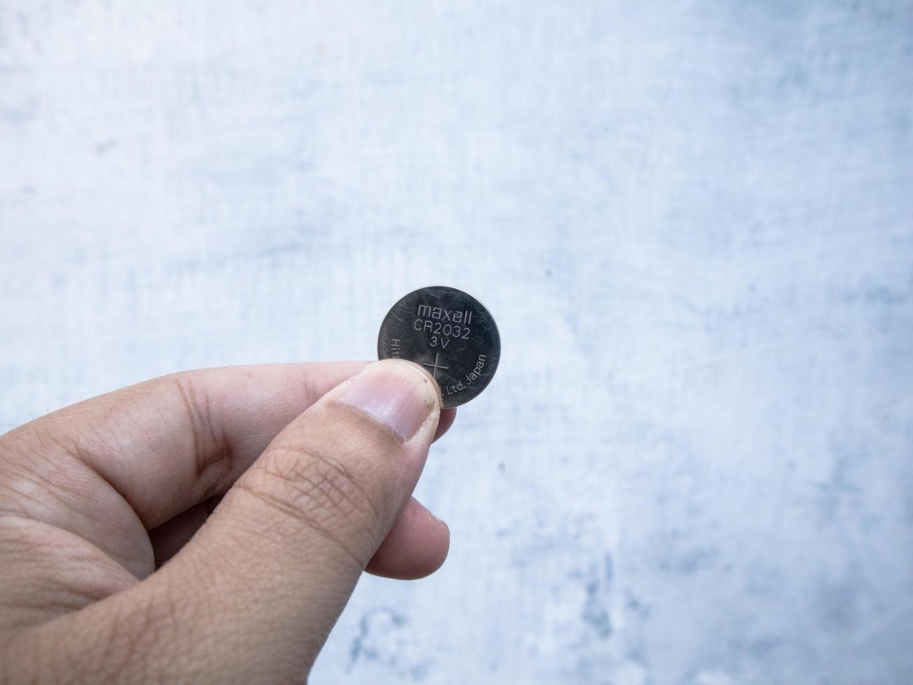 a man holding cmos battery in hand photo