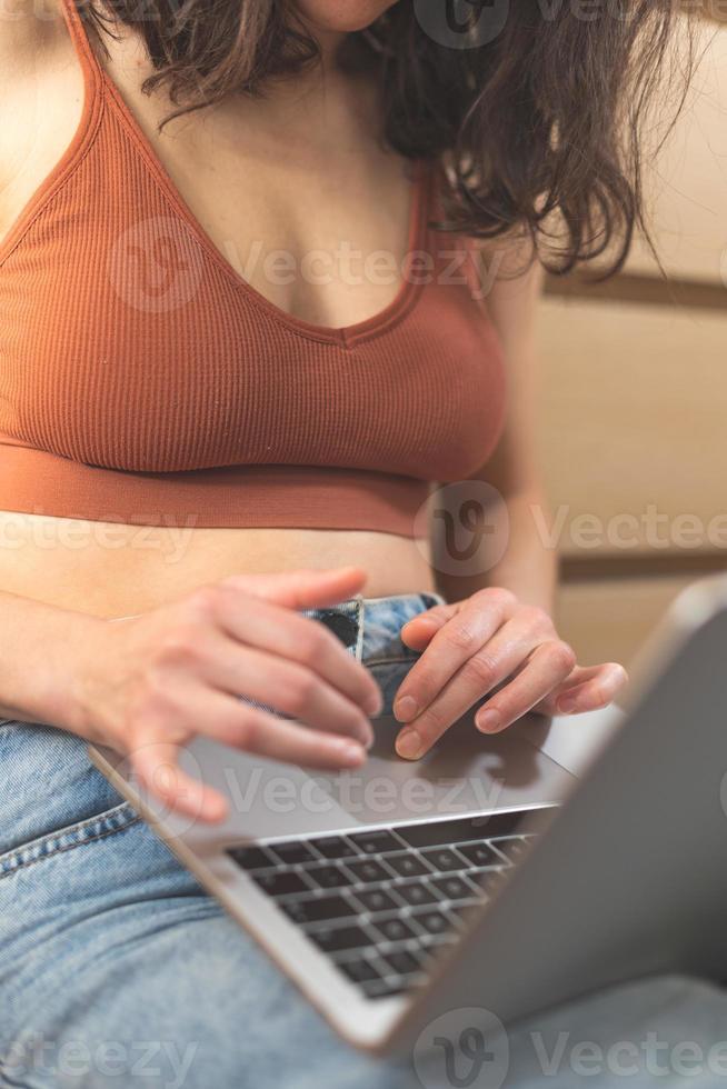 manos femeninas en el teclado, la chica trabaja en una laptop y escribe foto