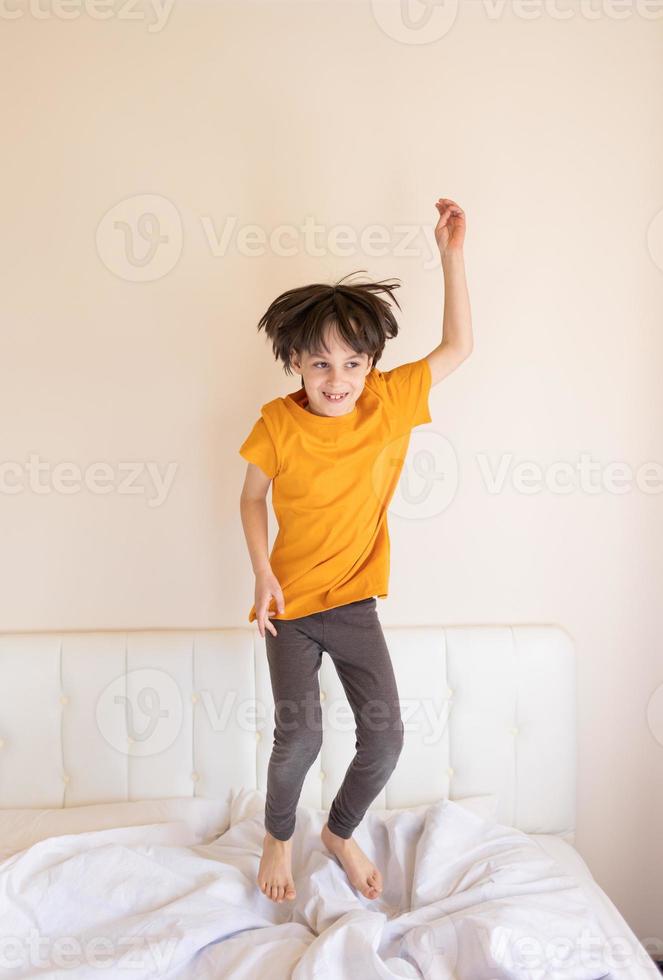 An energetic child is jumping on the bed photo