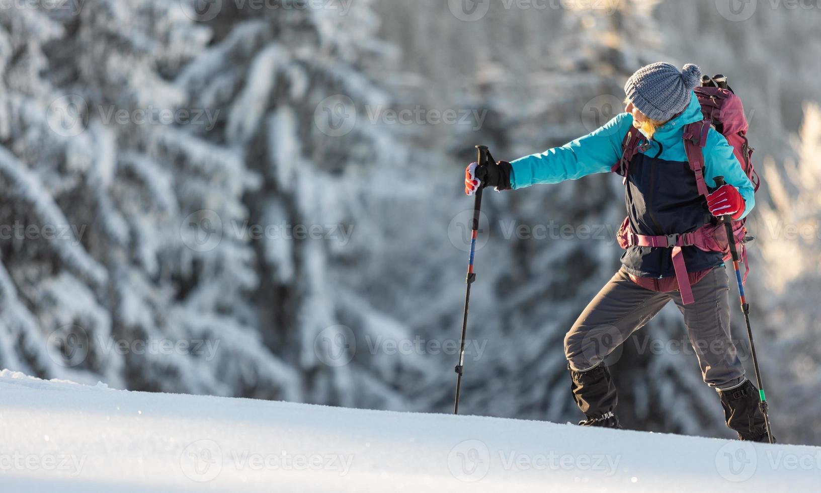 A hiker walks in snowshoes in the snow photo