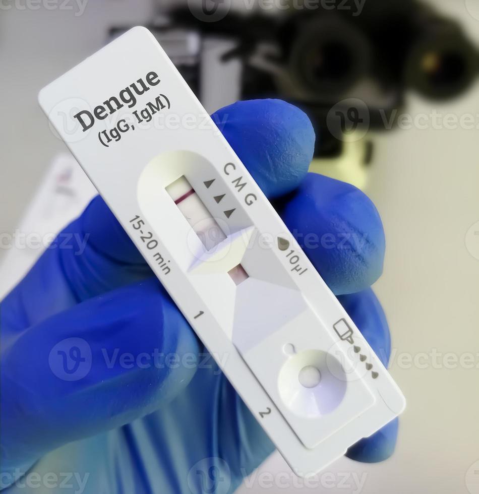 Technician glove hand hold rapid test cassette for dengue IgG, IgM rapid screening test showing positive IgG test. photo