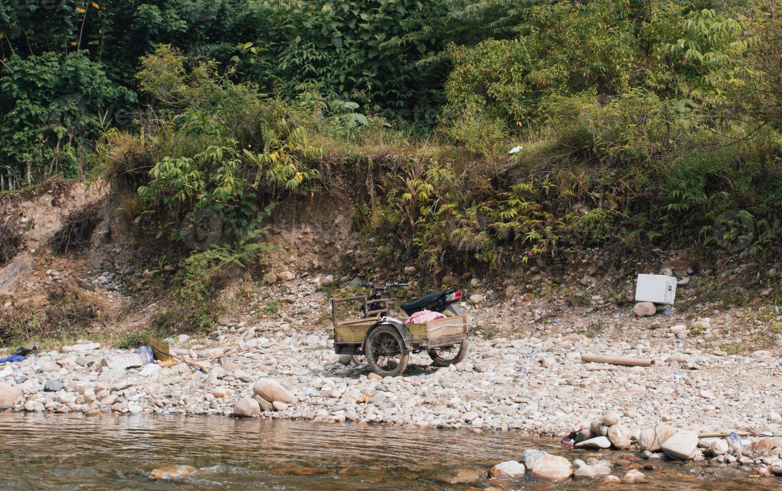 Old pedicab on the edge of the river photo