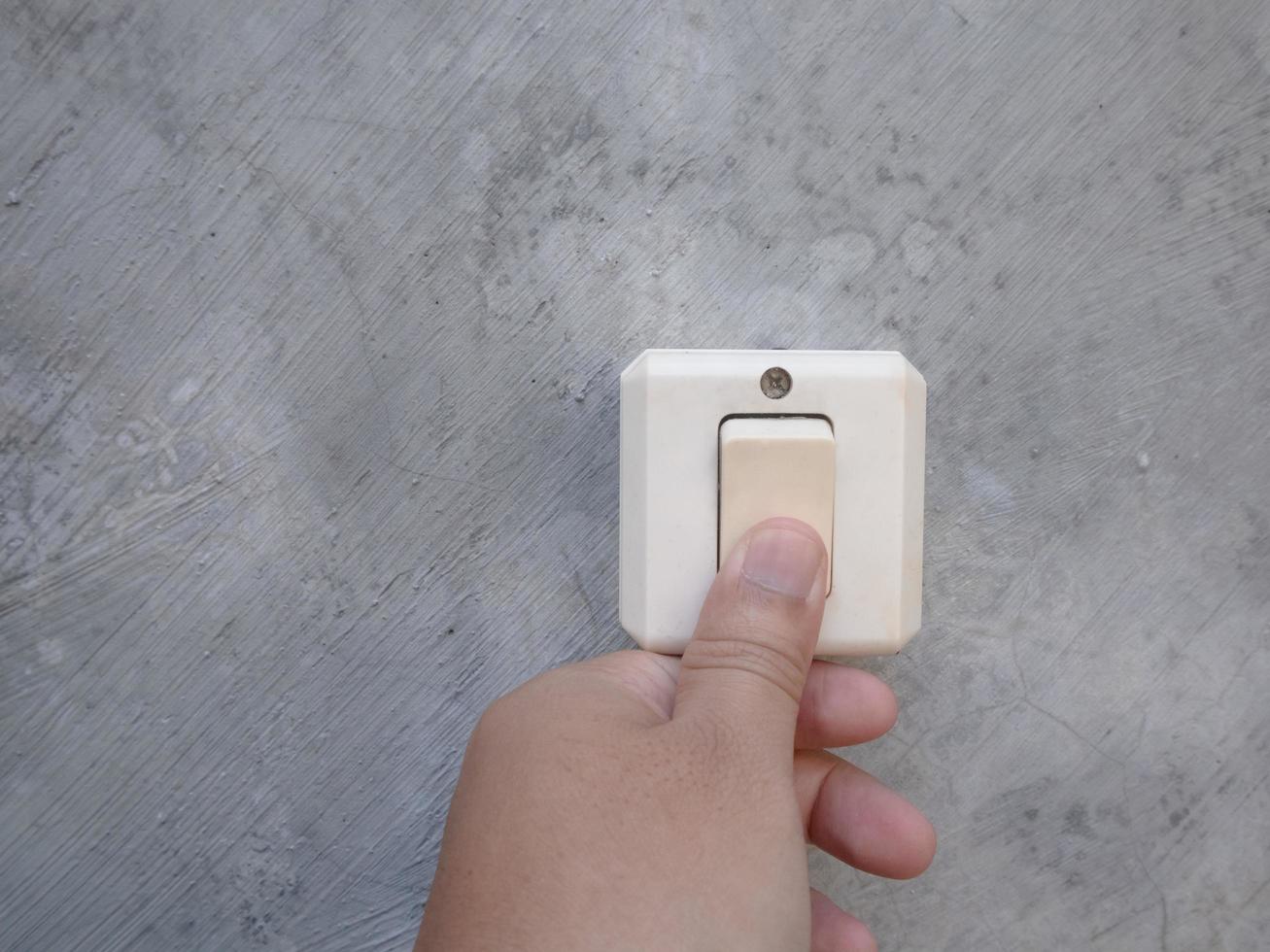 a man pushes the on switch button on the wall photo