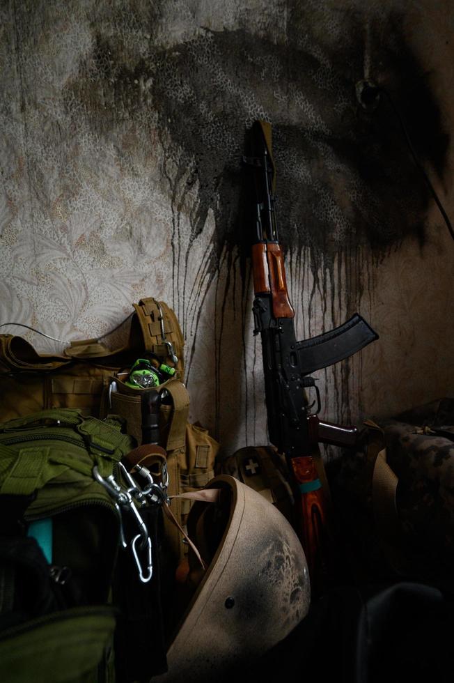 la ametralladora del soldado ucraniano está apoyada contra la pared de la casa, la guerra en ucrania. foto