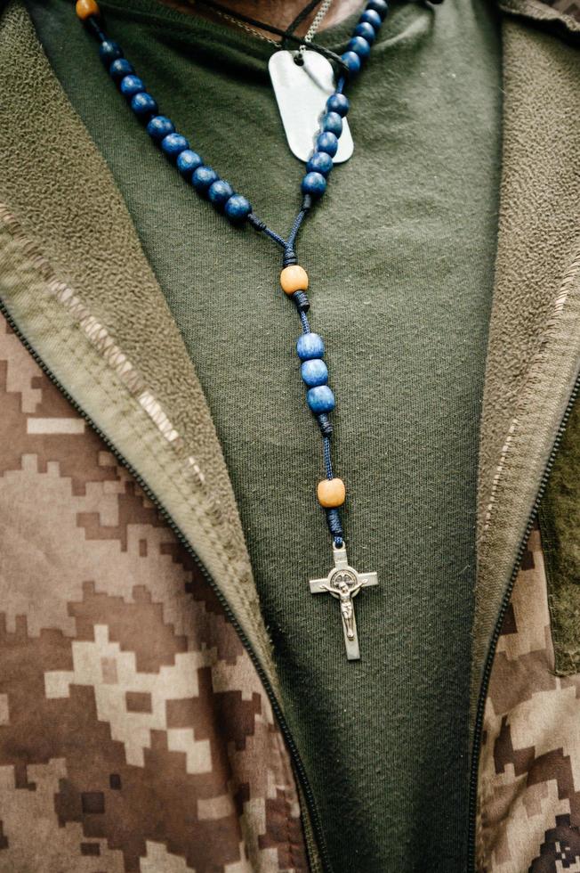el militar ucraniano lleva un rosario y placas de identificación militares en el pecho, foto