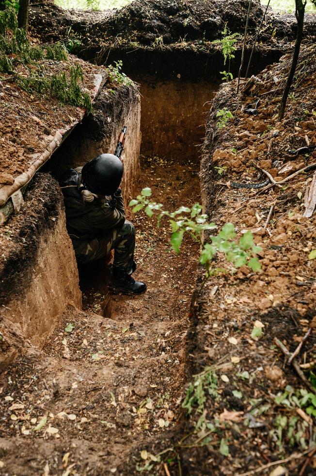 Soldier in a trench on the front line of the Ukrainian-Russian war, defense of Ukrainian borders from orcs. photo