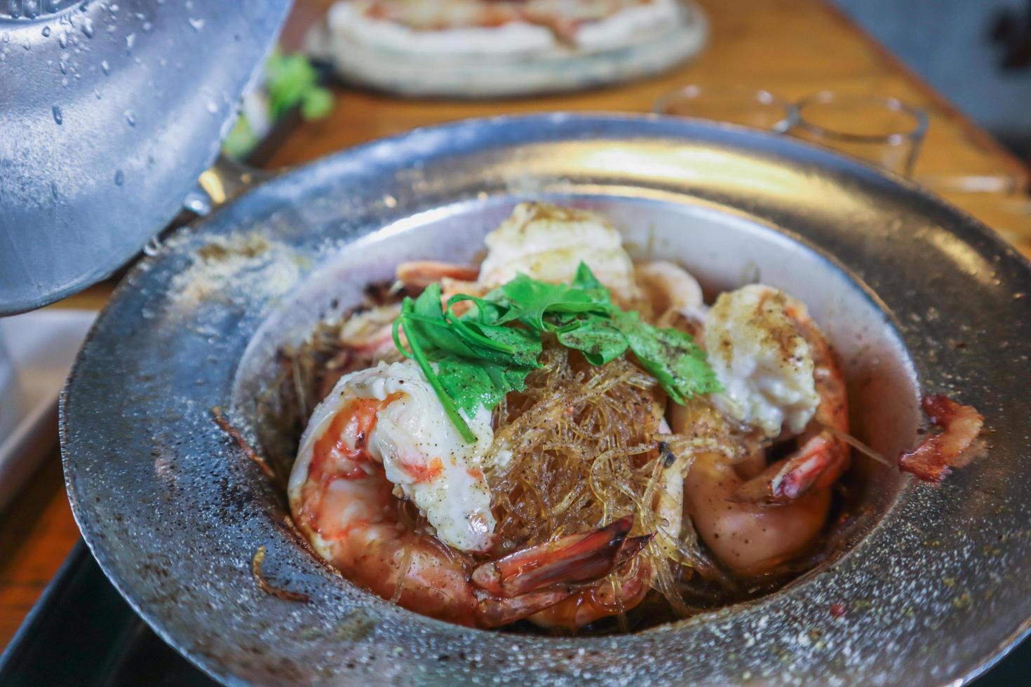 Baked river prawns with vermicelli in a pot is a very popular dish in Thailand because it is easy to make and delicious. River prawns and vermicelli in the casserole are seasoned with a special sauce. photo