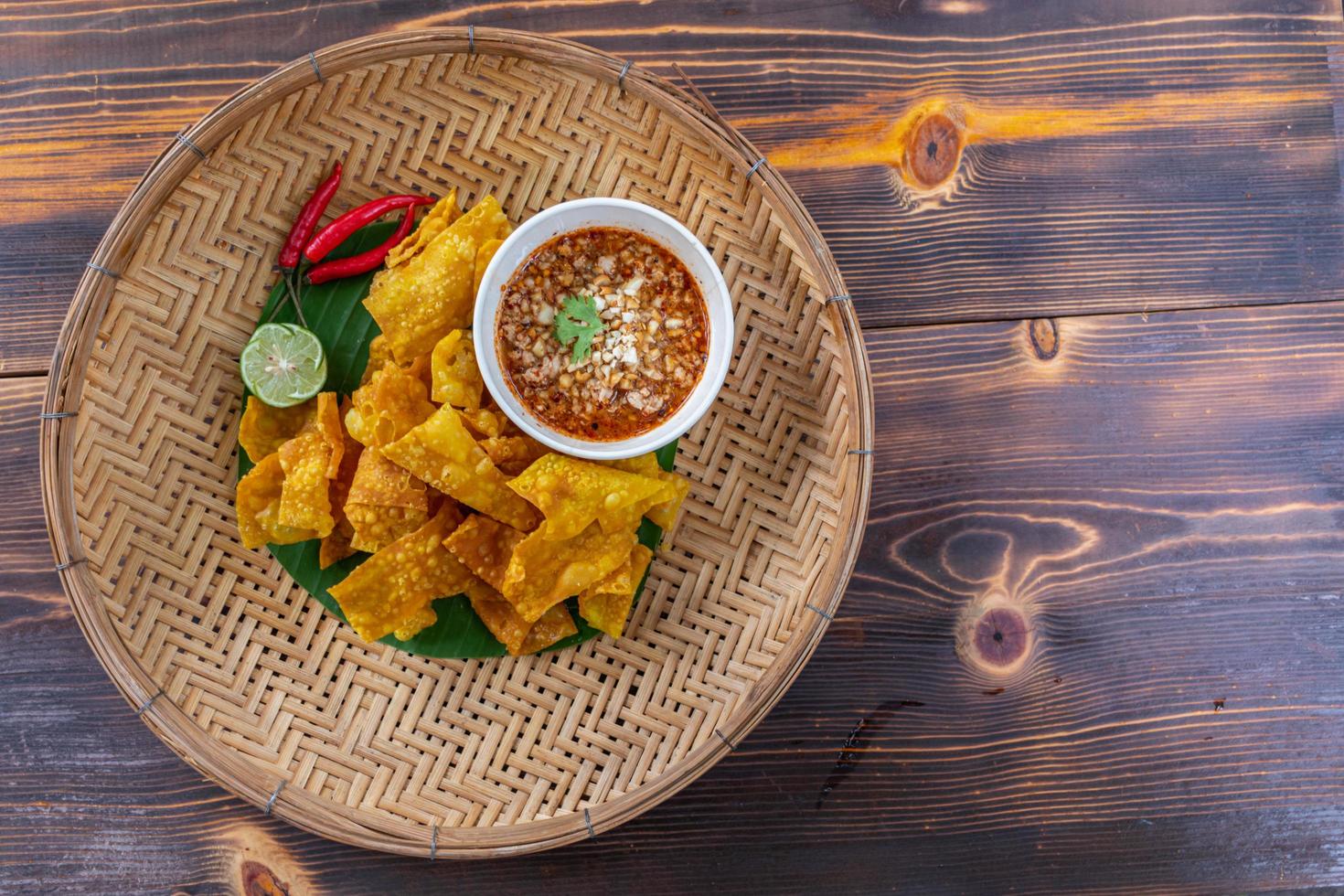 albóndigas crujientes envueltas en pollo, verduras y especias se sirven en un plato blanco colocado sobre una mesa de madera dentro del restaurante. Las albóndigas fritas son populares por su delicioso sabor. foto