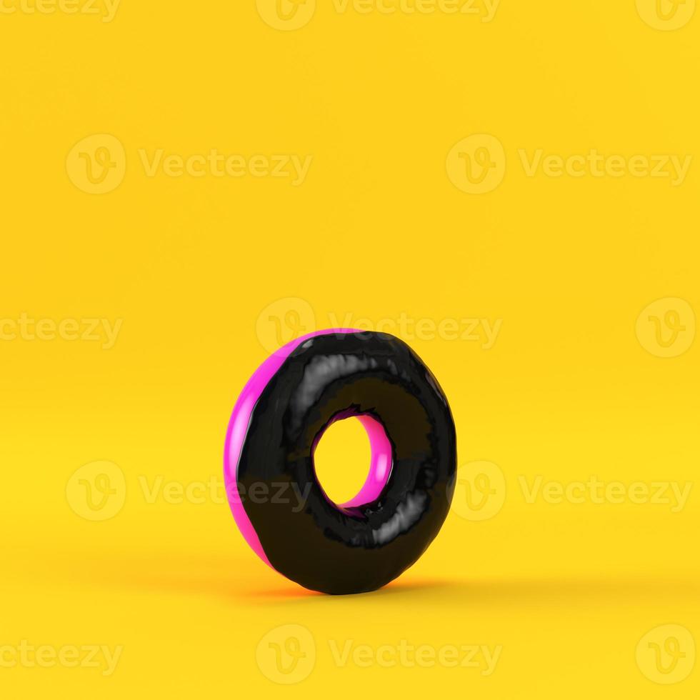Donut with black glaze on yellow background photo