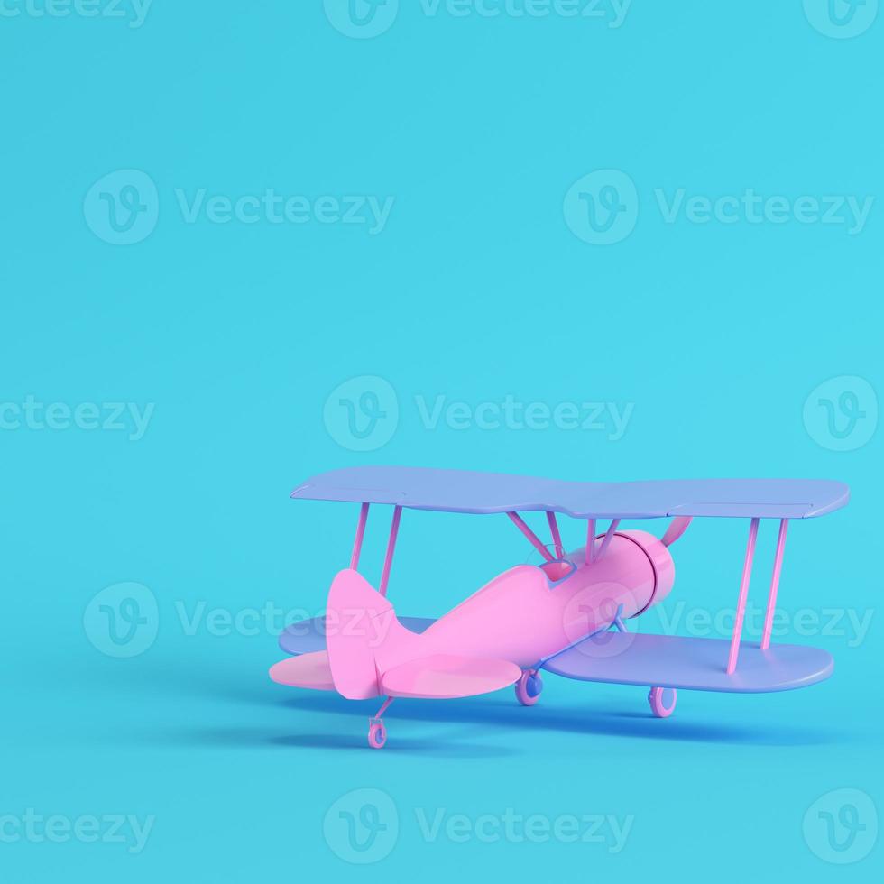 Pink biplane on bright blue background in pastel colors. Minimalism concept photo