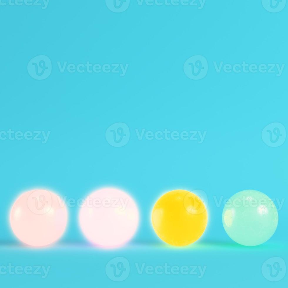 Four colorful crystal balls on bright blue background in pastel colors. photo