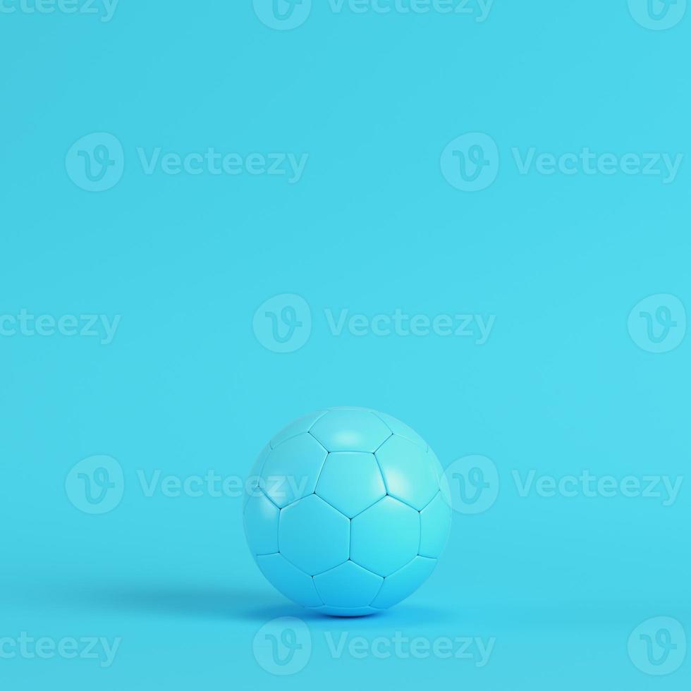 Soccer ball on bright blue background in pastel colors photo