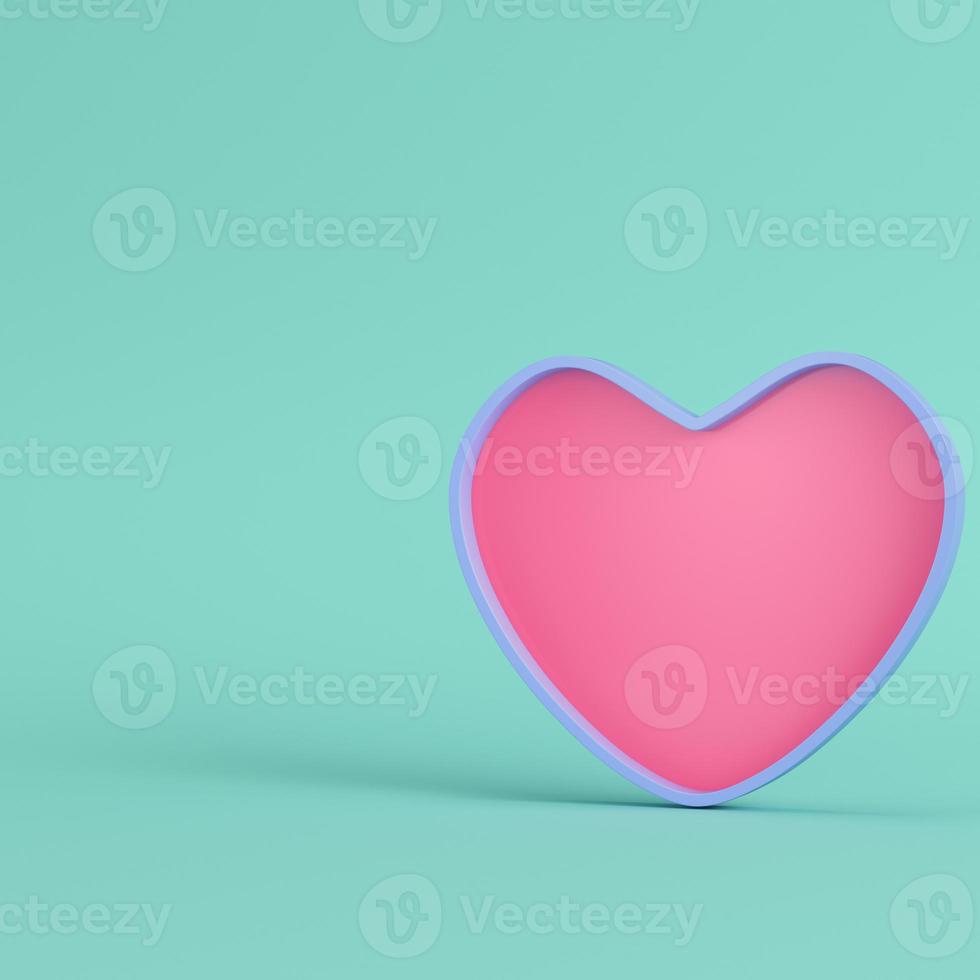 Pink heart with blue frame on bright green background in pastel colors. Minimalism concept photo