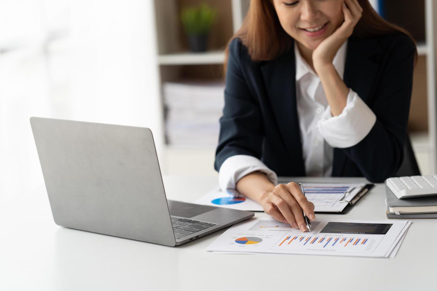 Portrait of confident businesswoman at workplace, smiling woman employee sitting behind laptop. photo