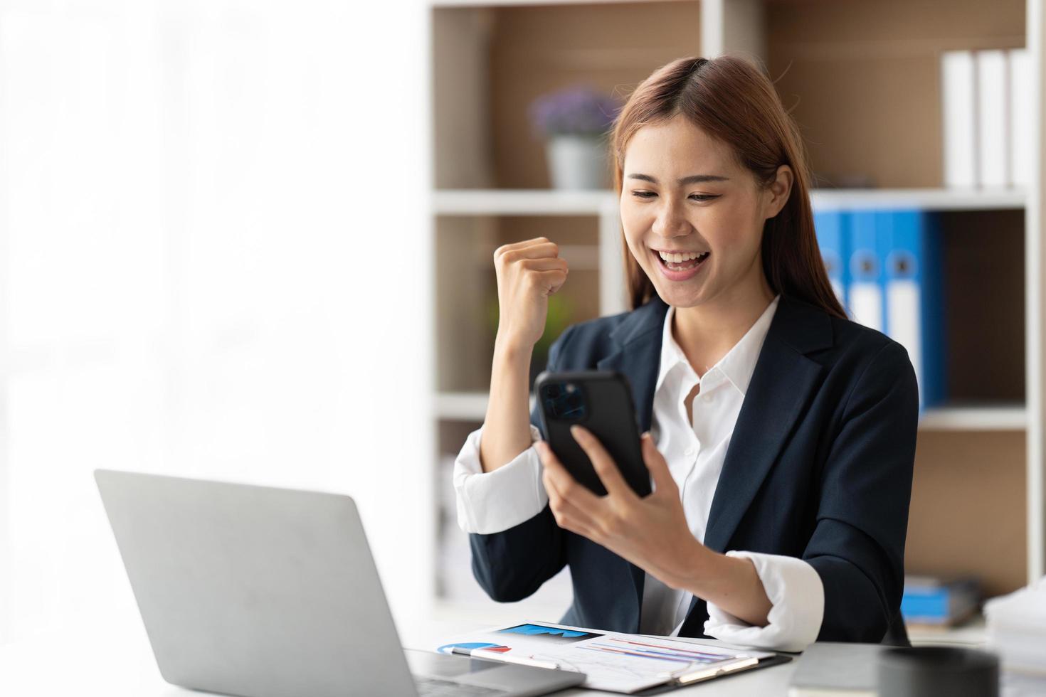 Online shopping and beauty concept. Excited asian woman winning in internet, holding smartphone and rejoicing, smiling happy and celebrating. photo