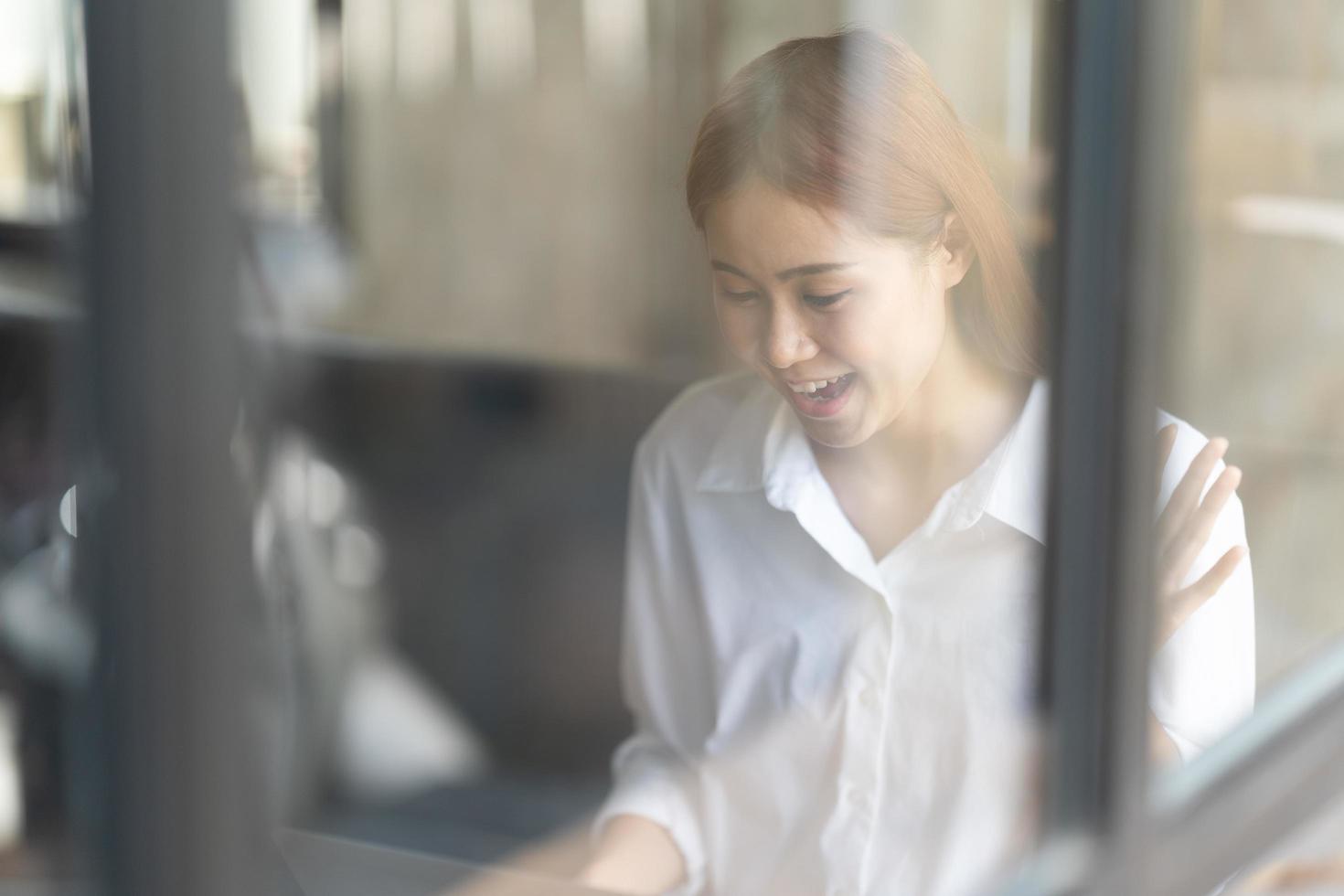 Portrait of confident businesswoman at workplace, smiling woman employee sitting behind laptop. photo