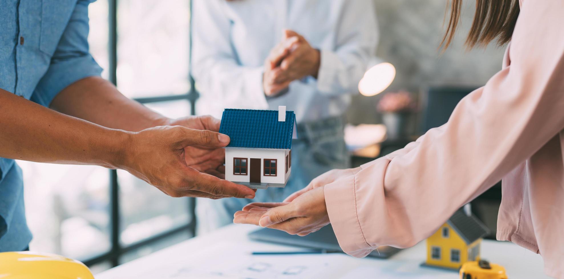 A group of architects are designing a house model, engineers and architects working together to plan a house building project. photo