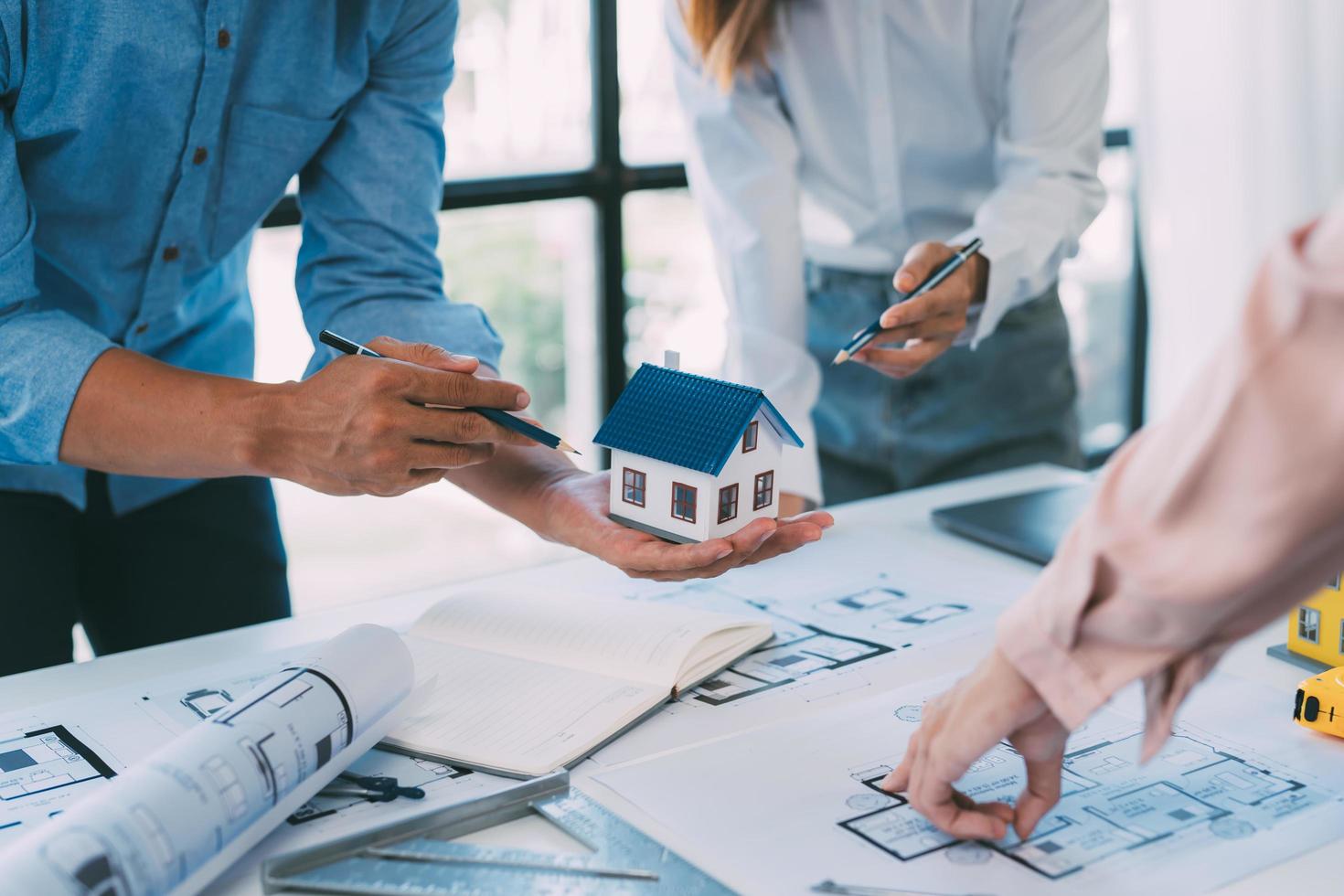 A group of architects are designing a house model, engineers and architects working together to plan a house building project. photo