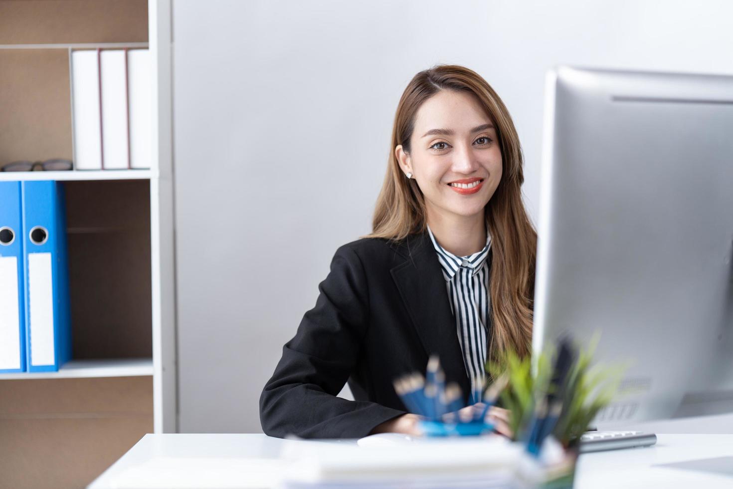 el retrato de una joven empresaria asiática está feliz de trabajar en la oficina moderna usando una computadora portátil. concepto de telemarketing de comercio electrónico de marketing en línea independiente para empleados de negocios. foto