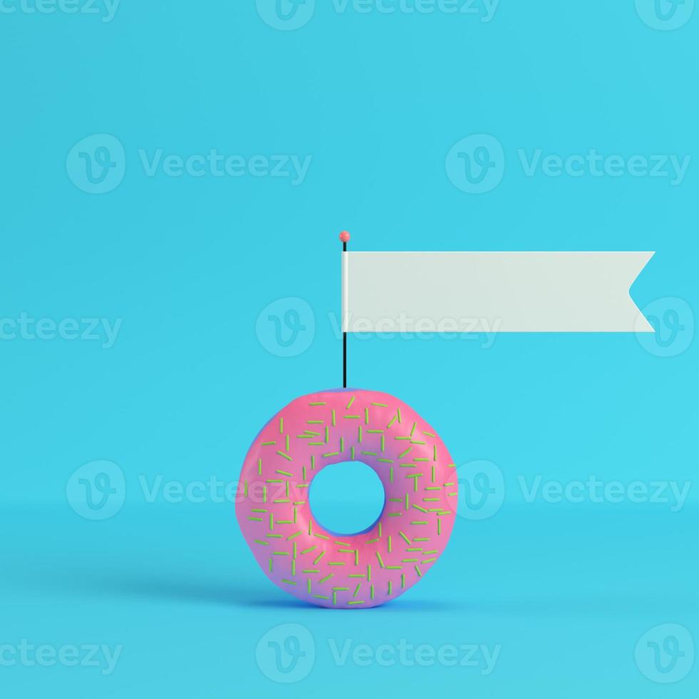 Donut with blank flag on bright blue background in pastel colors photo