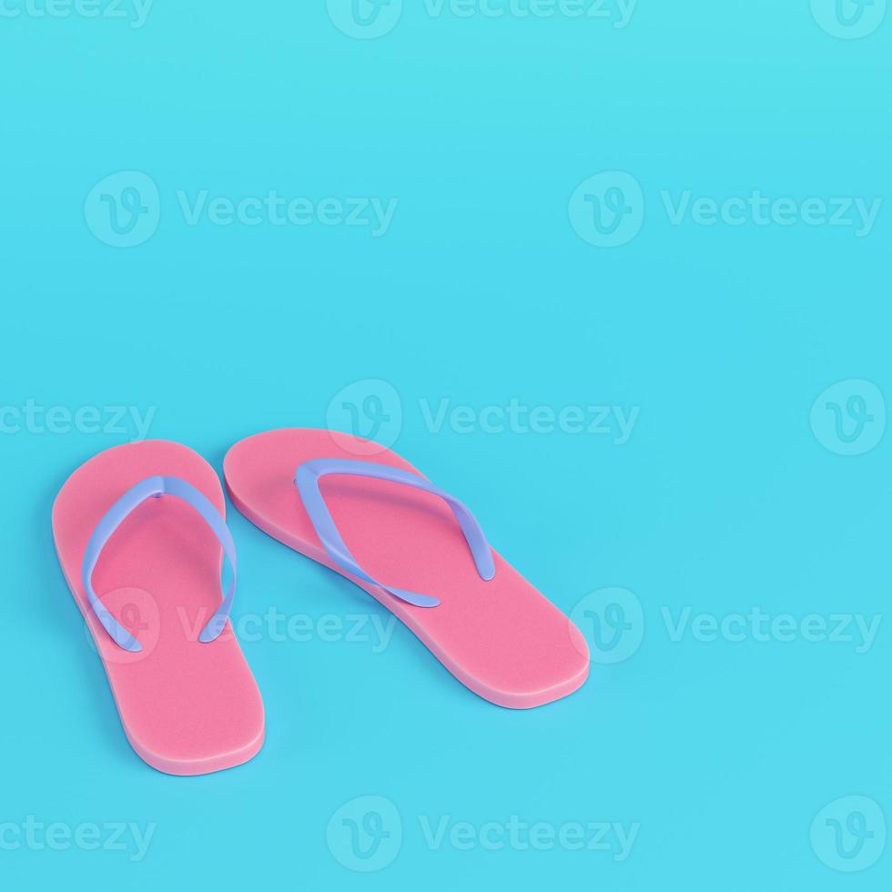 Pink flip flops on bright blue background in pastel colors photo