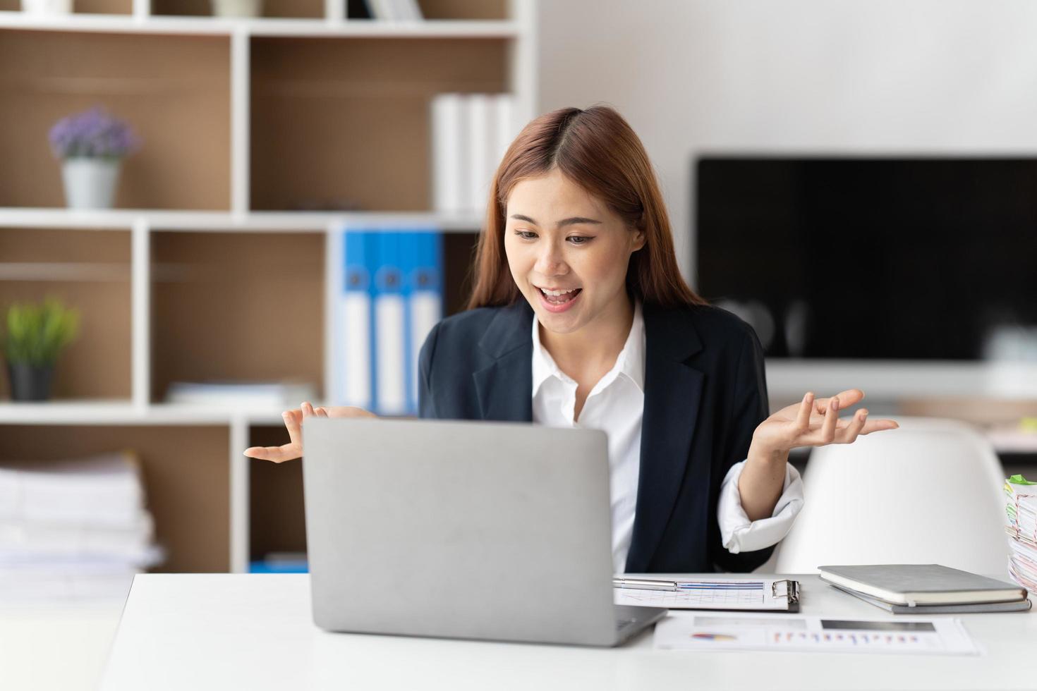 Young attractive business asian woman talking about sale report in video call conference on notebook computer online meeting in working from home. photo